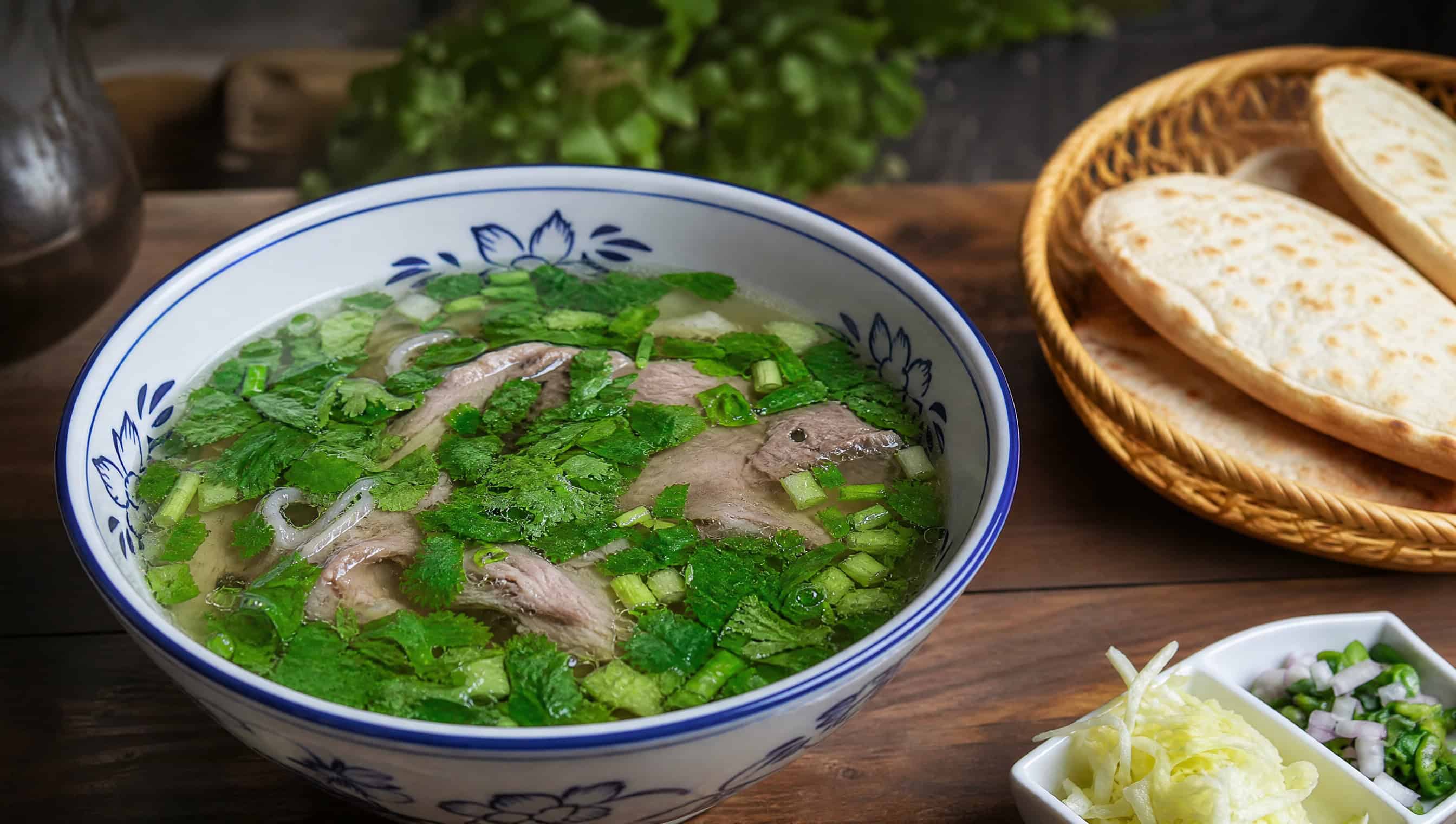 Shuipen yangrou — clear mutton broth with thin-sliced lamb, vermicelli and flatbread on the side